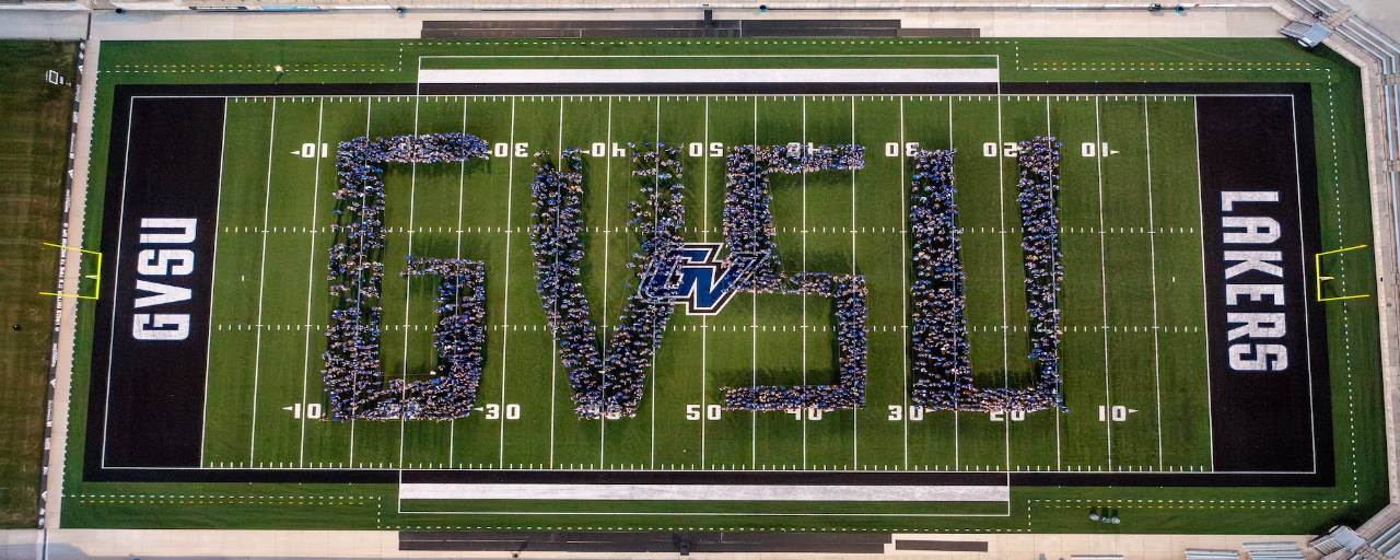 first-year students in fall of 2024 stand in formation to create the letters G V S U on the football field